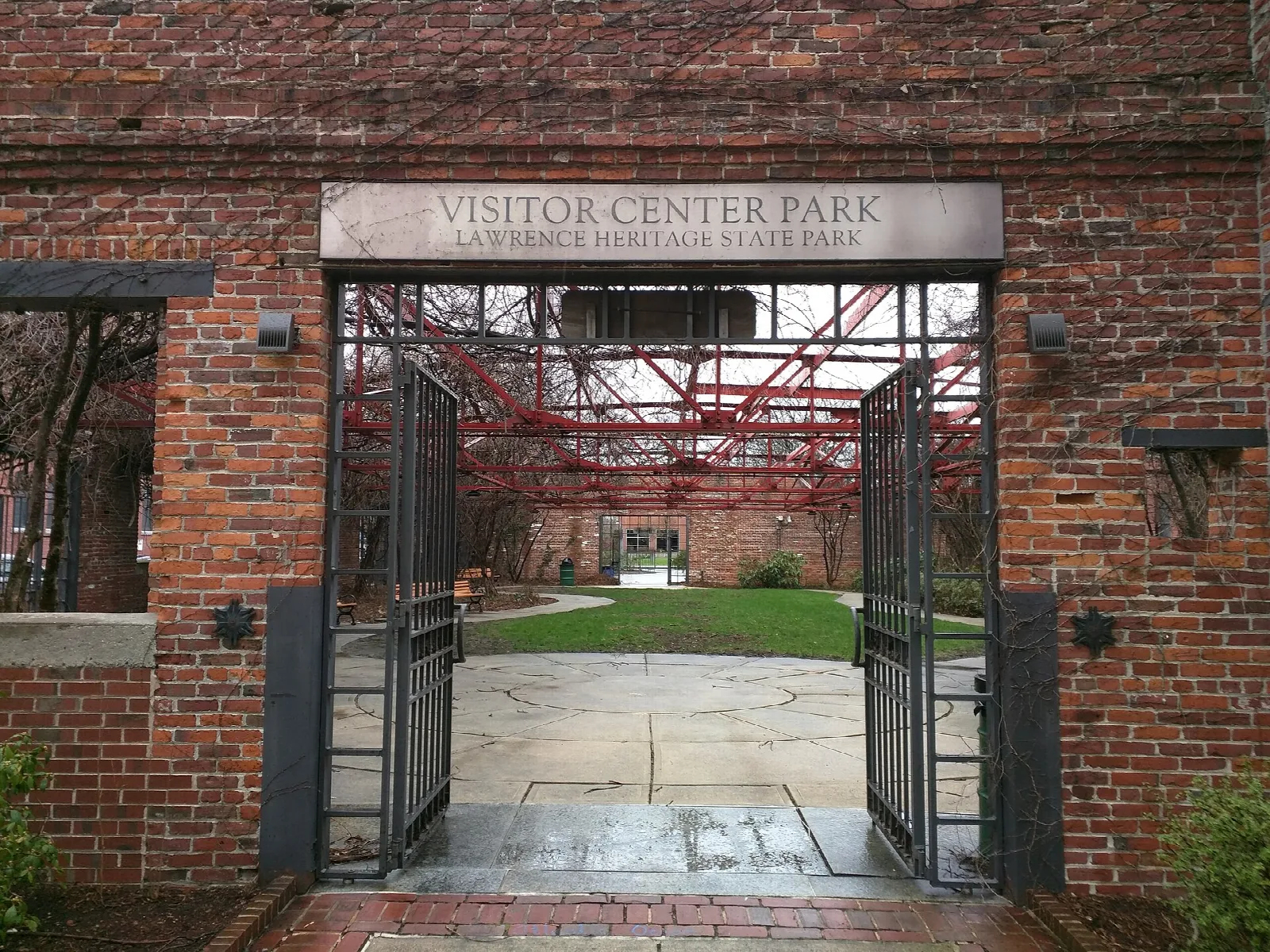 Red brick gateway with a Visitor Center Park sign over an iron gate