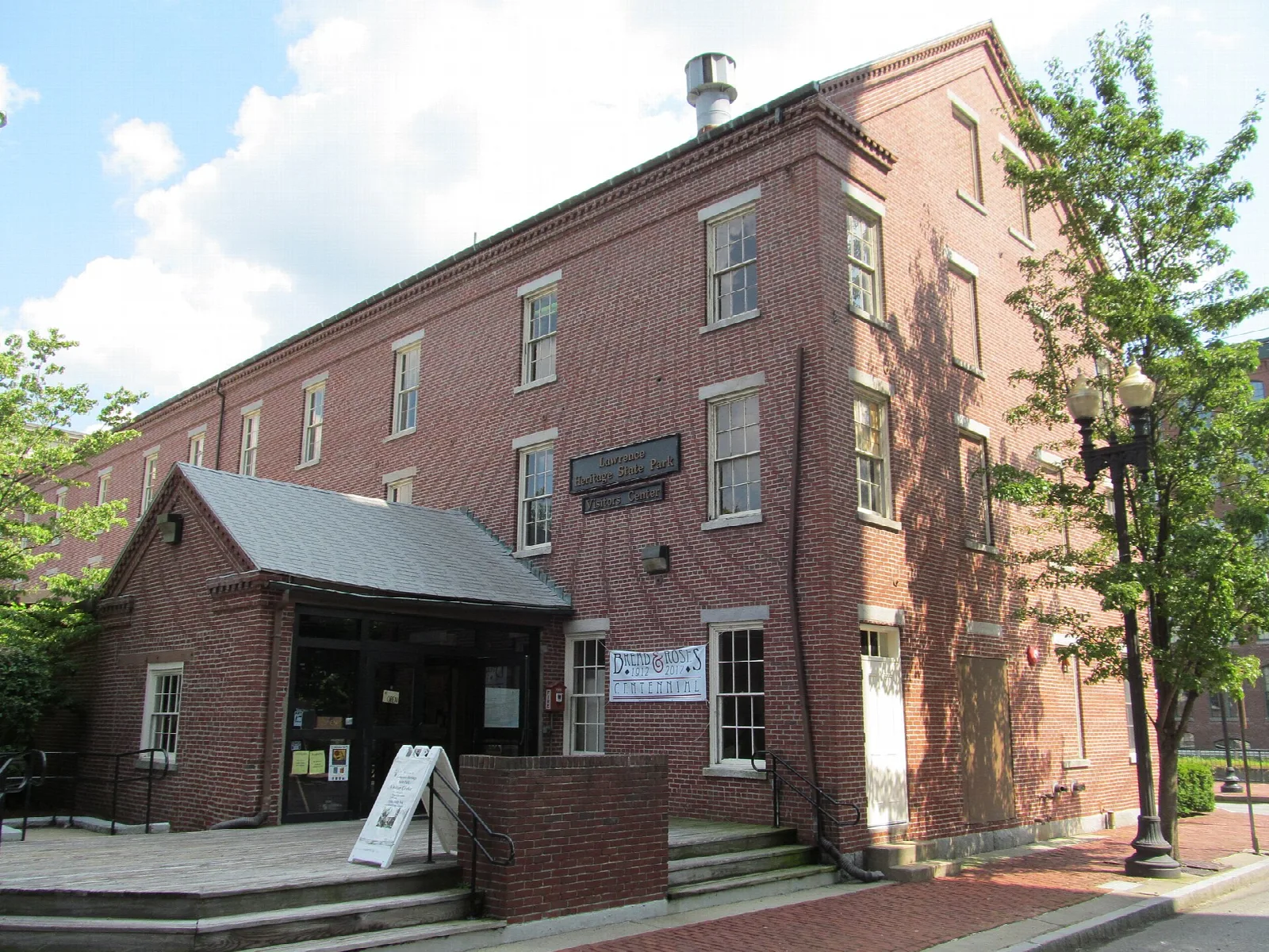 Red brick visitor center building with a small entrance porch and a sign