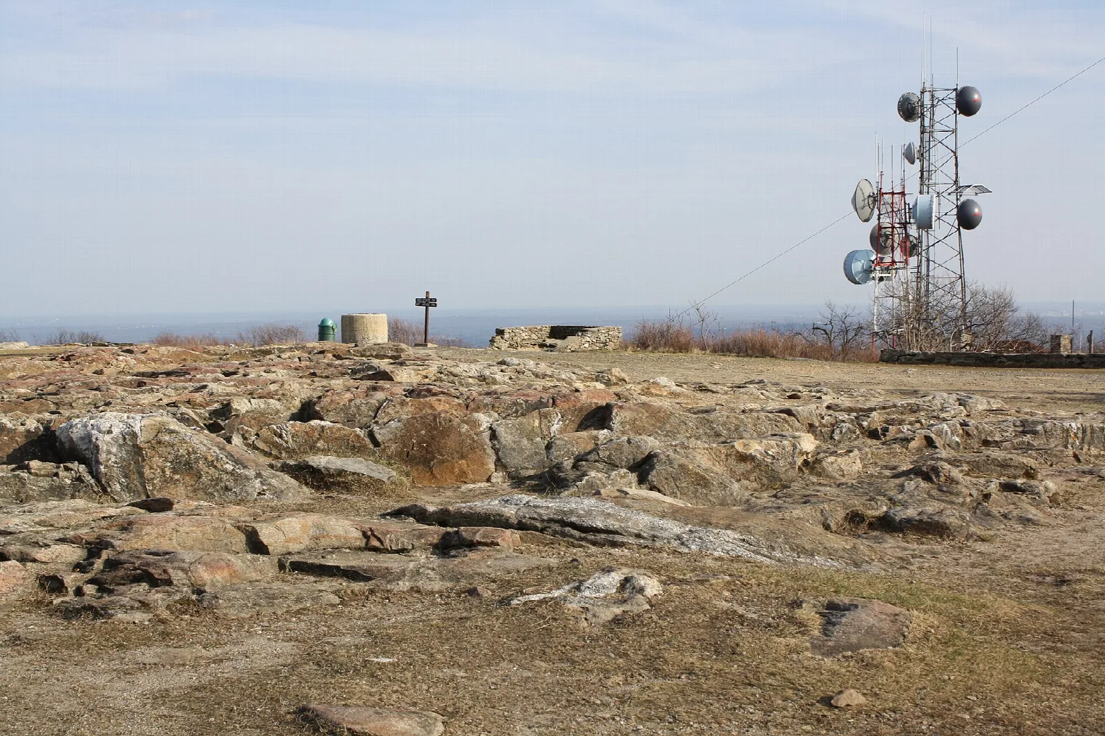 Flat bedrock summit with a radio tower on the horizon