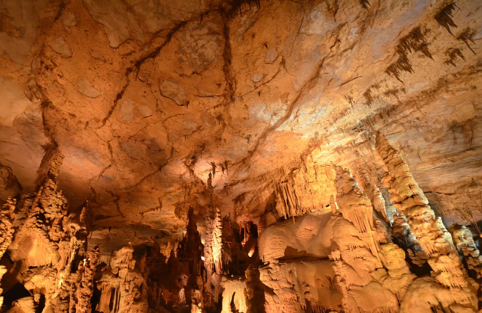 Orange-lit cave ceiling above rows of rock formations