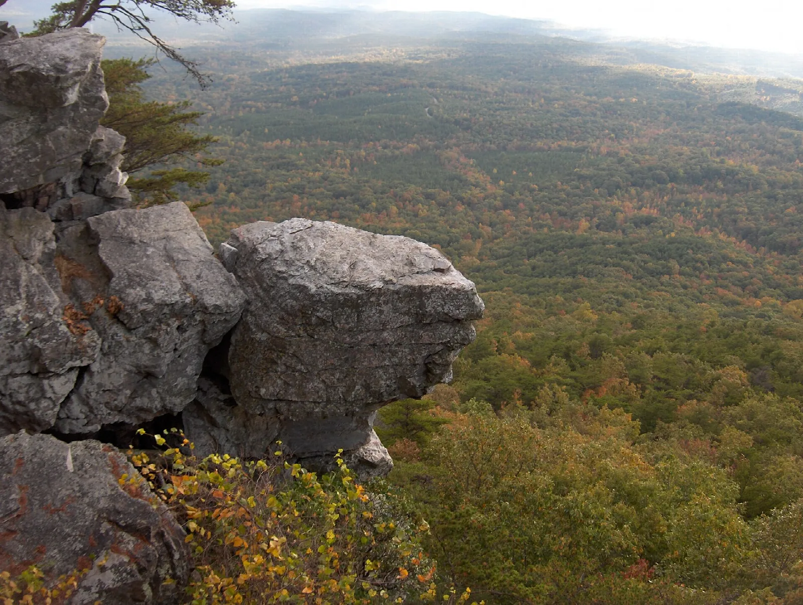 Large rock outcrop at the edge of a wooded valley in autumn