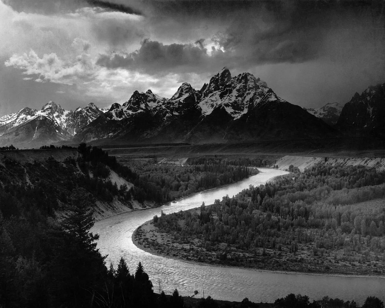 Black-and-white photograph of the Snake River curving through a valley toward the Teton Range