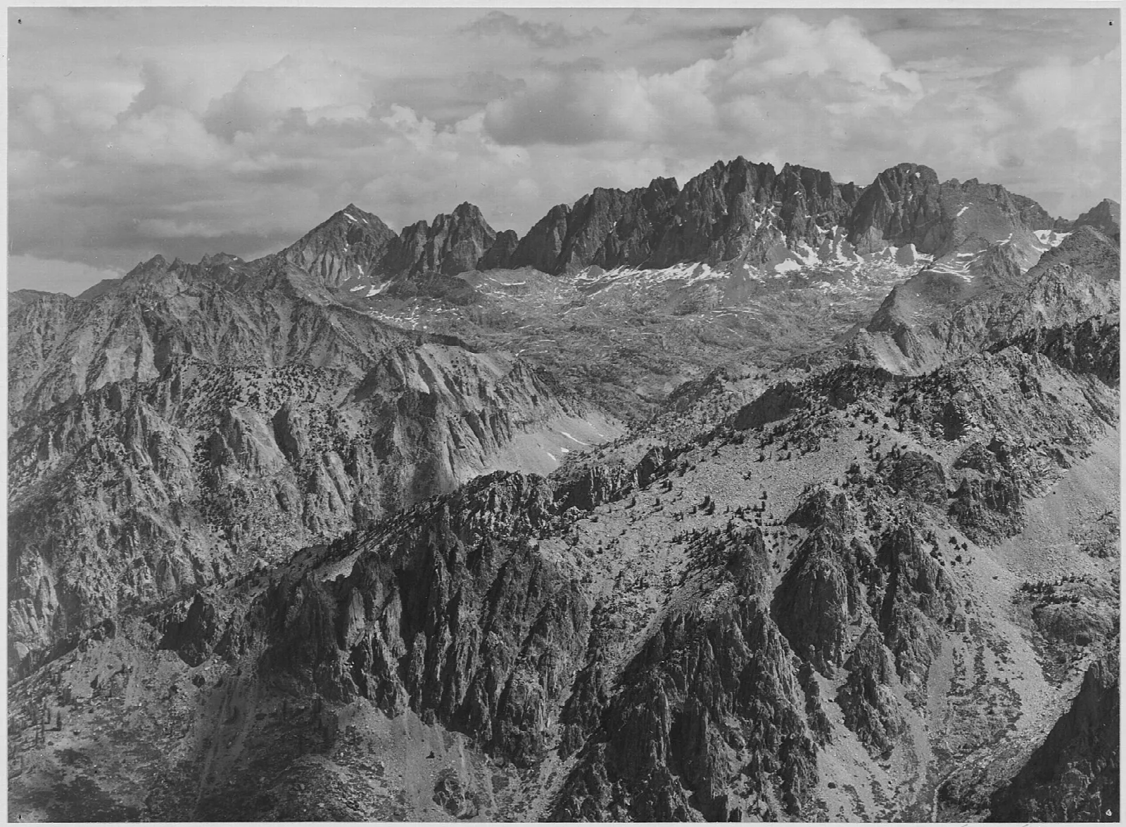Black-and-white photograph of a sweeping range of jagged High Sierra peaks