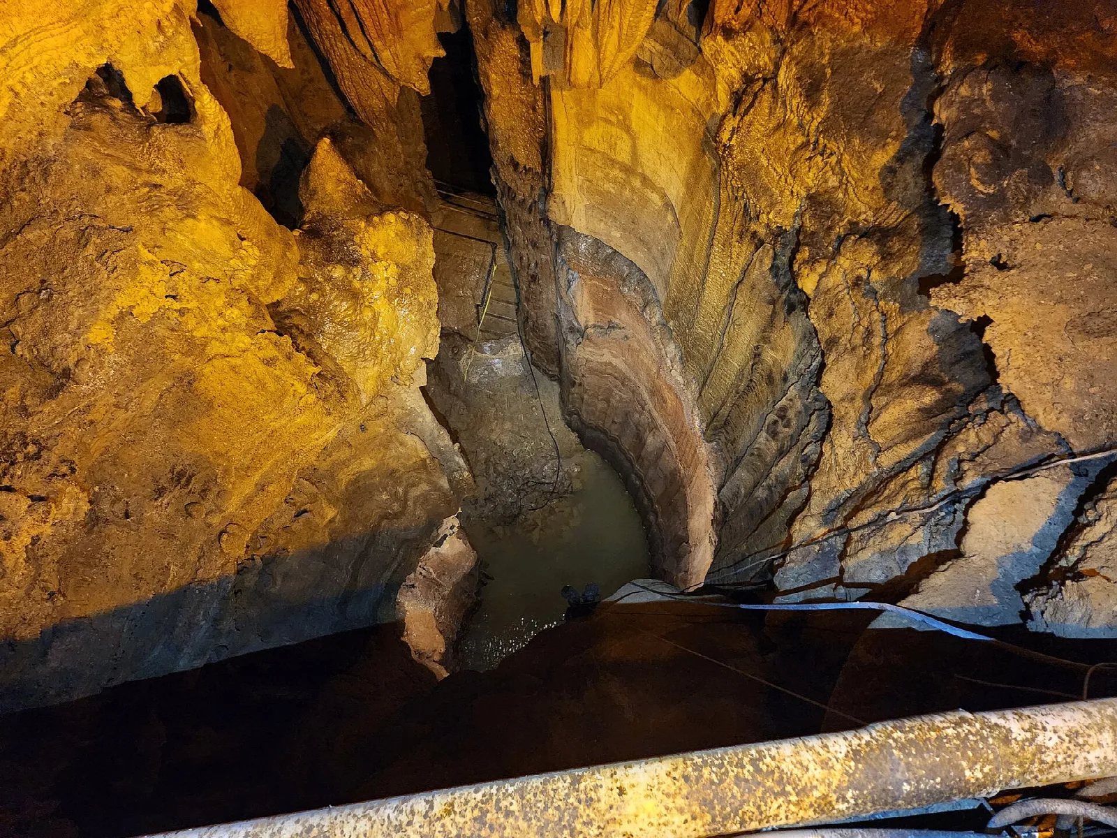 Golden flowstone cascading down a cave wall like a frozen waterfall