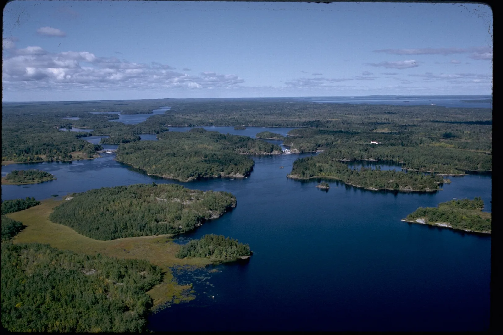 Aerial view of forested islands scattered through deep blue lakes