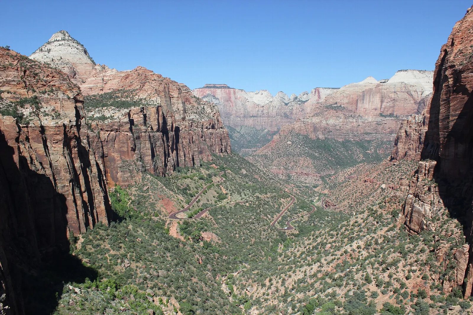Looking down a sheer-walled canyon of red and white sandstone