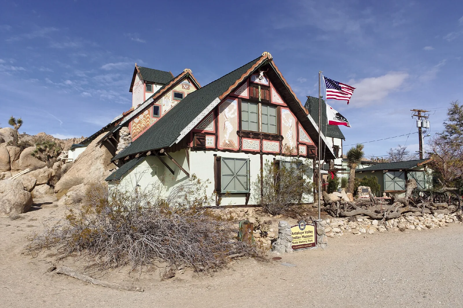 Museum building with gabled roofs among rocks and desert trees