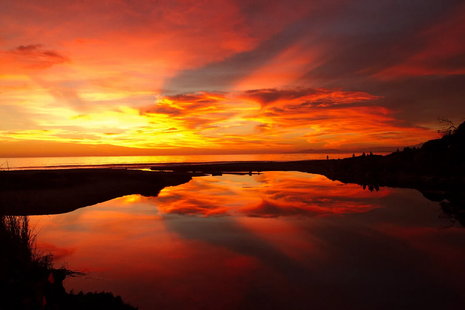 Red and orange sunset reflected in a calm lagoon