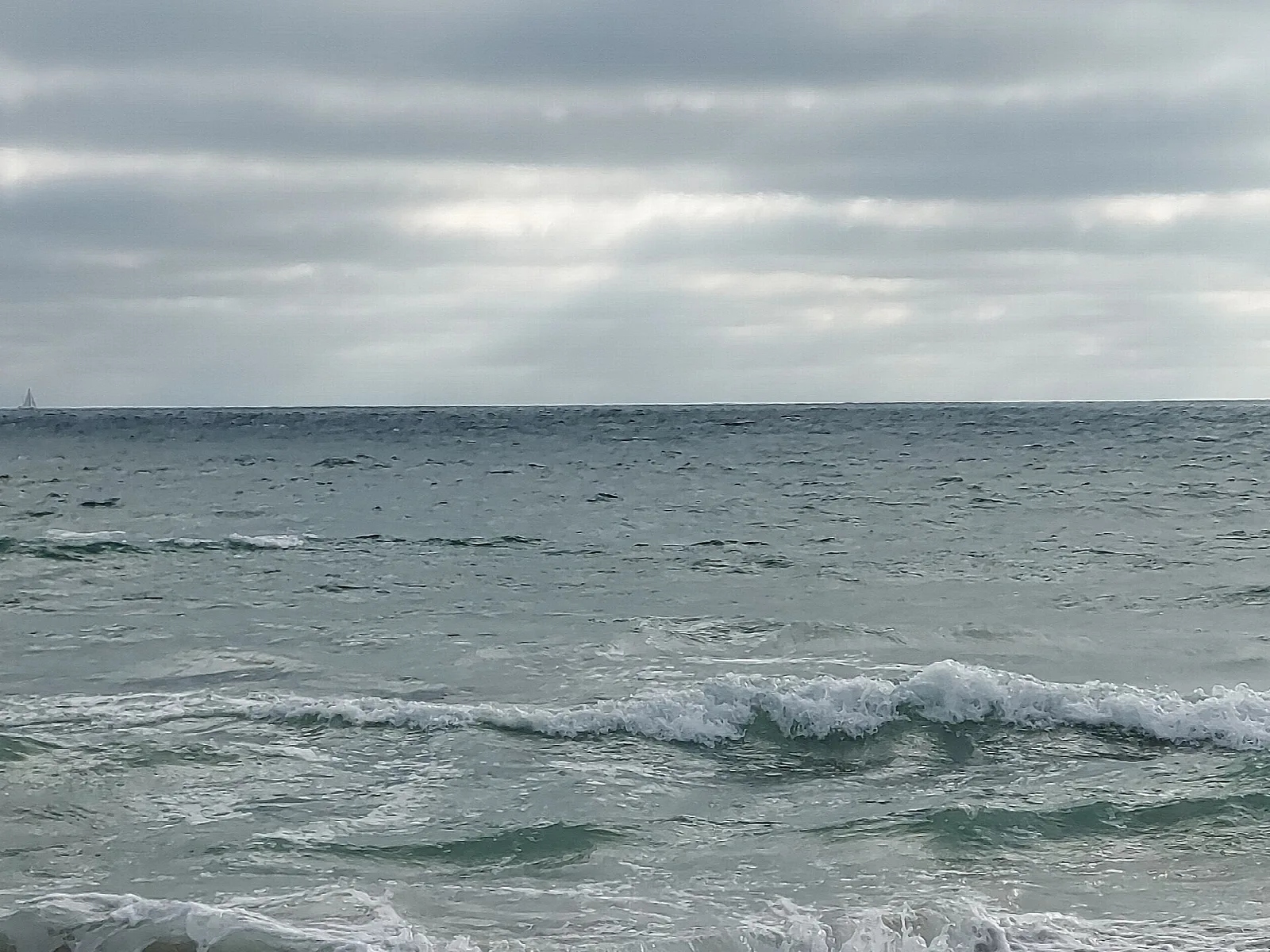 Ocean waves under a cloudy sky
