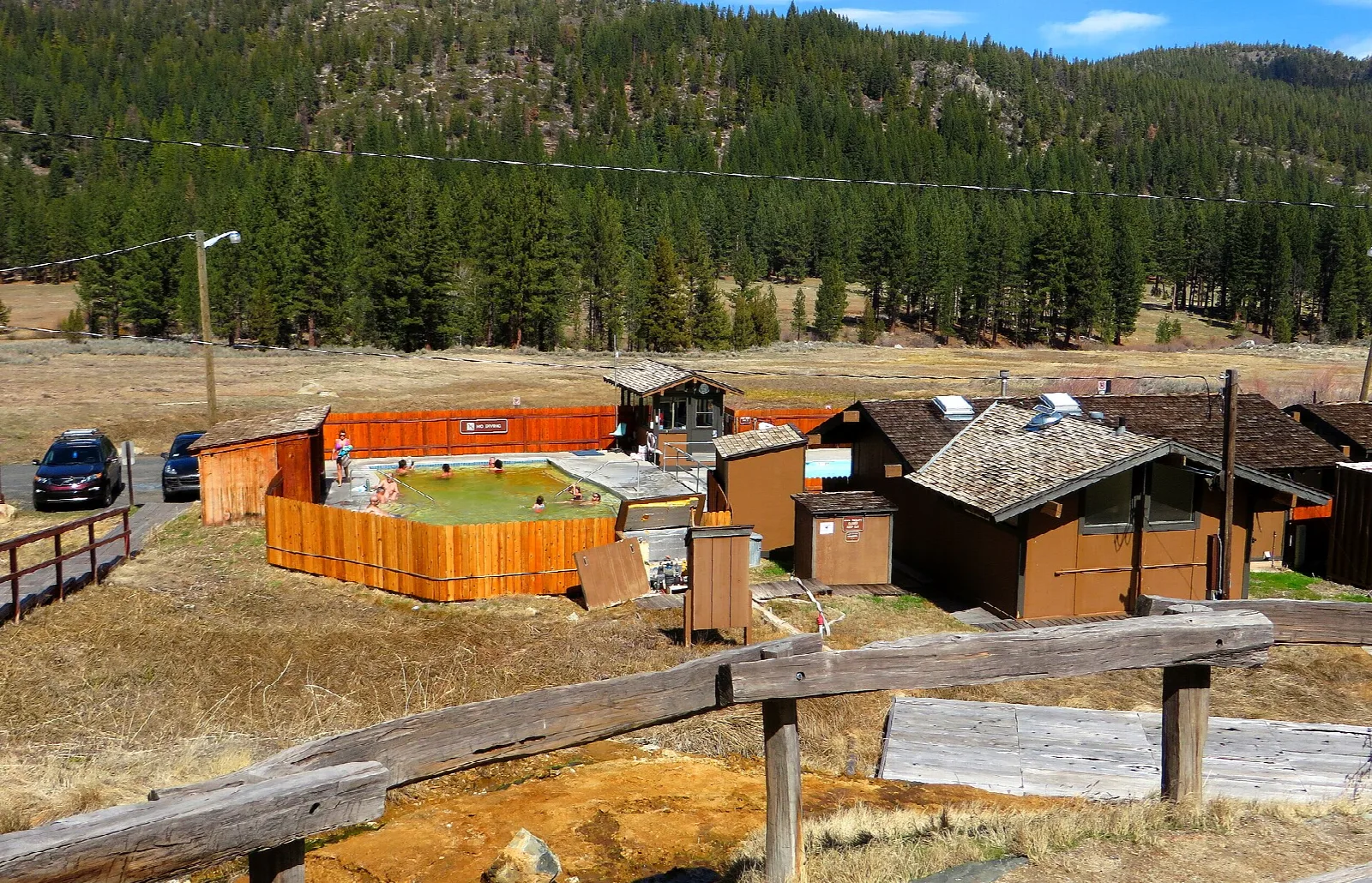 Wooden pool buildings and fenced pools among pines