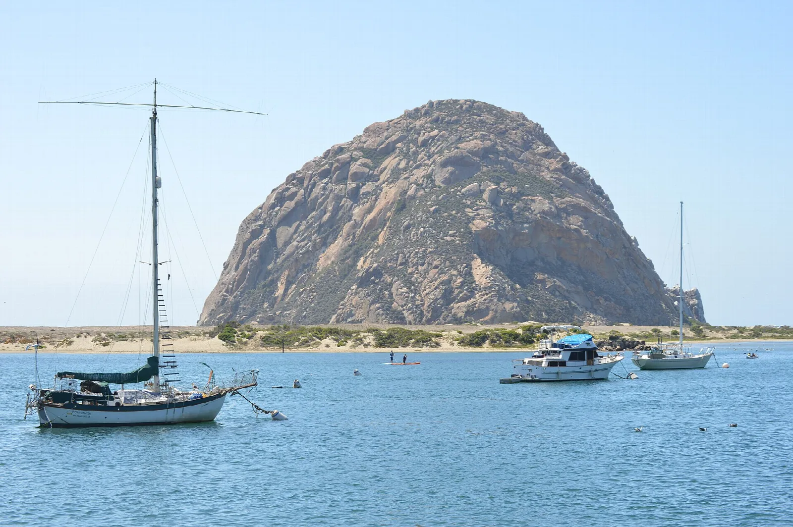 Sailboat and Morro Rock on bright blue water