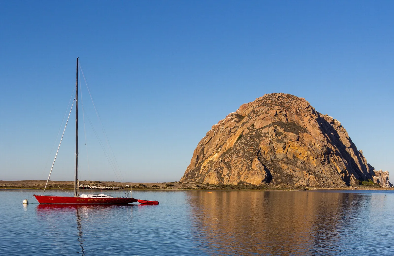 Sailboat on calm water in front of Morro Rock
