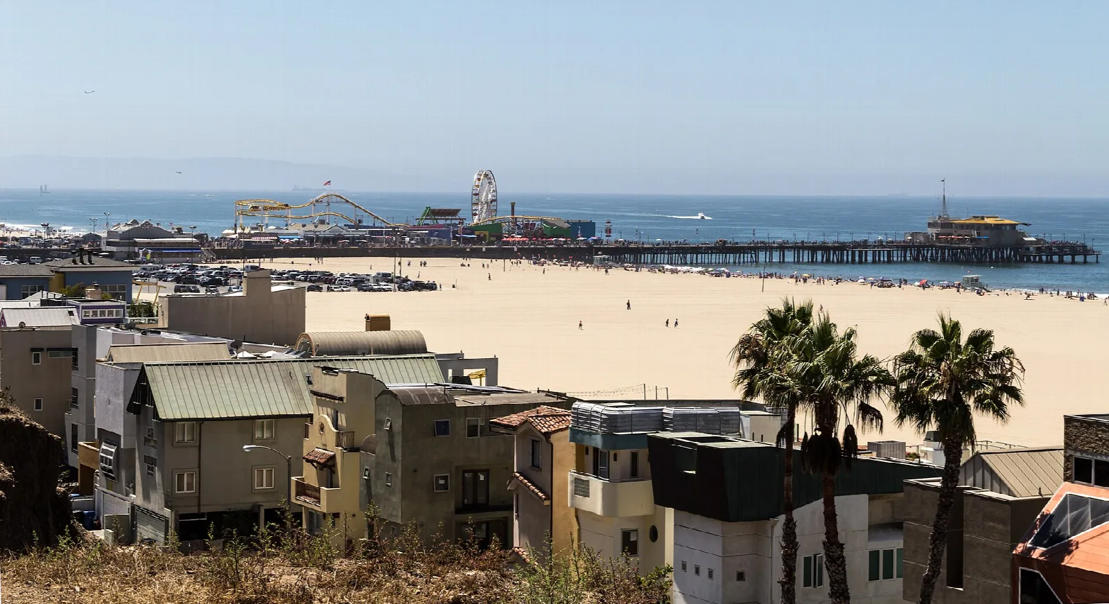Beach and pier seen from the hillside with the ocean beyond