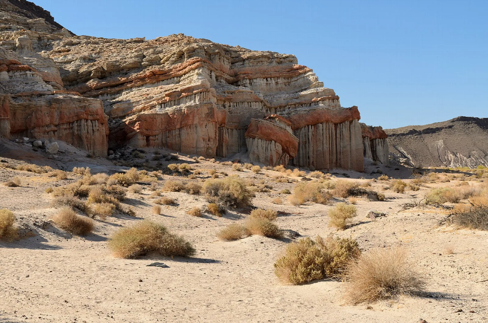 Layered red rock cliffs above desert scrub