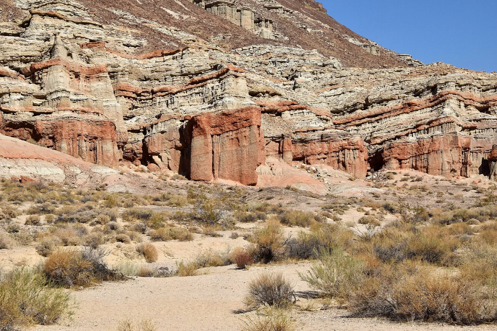Banded sandstone cliffs above sage scrub