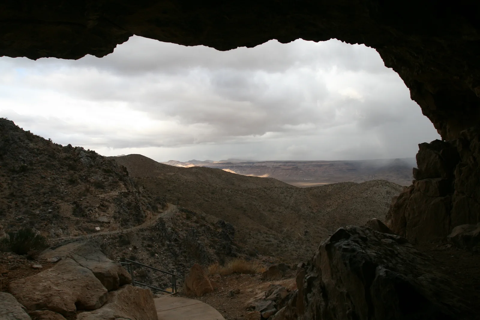 View of desert hills and sky from inside a cave opening