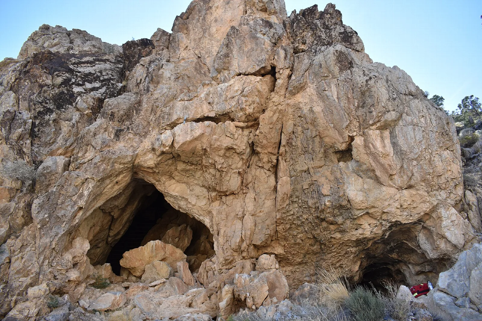 Large rock outcrop with a cave opening at its base