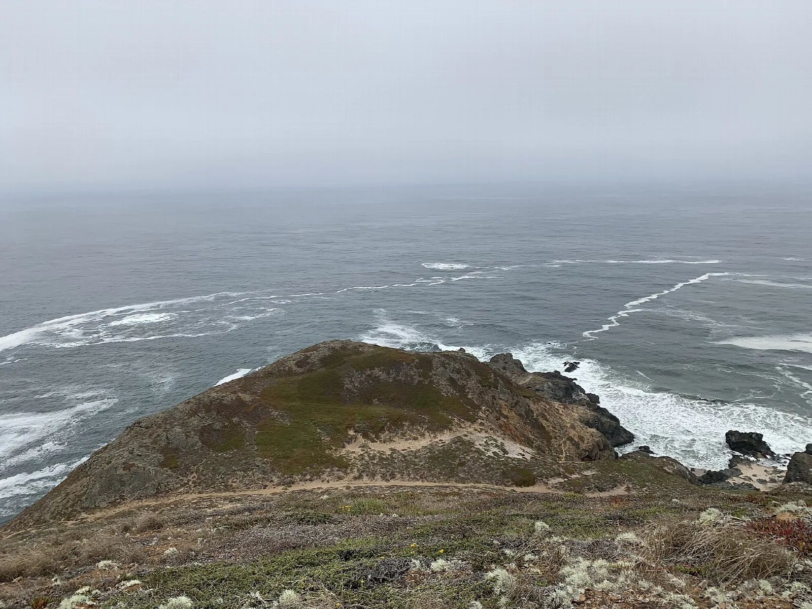 Rocky headland and surf seen from a high overlook
