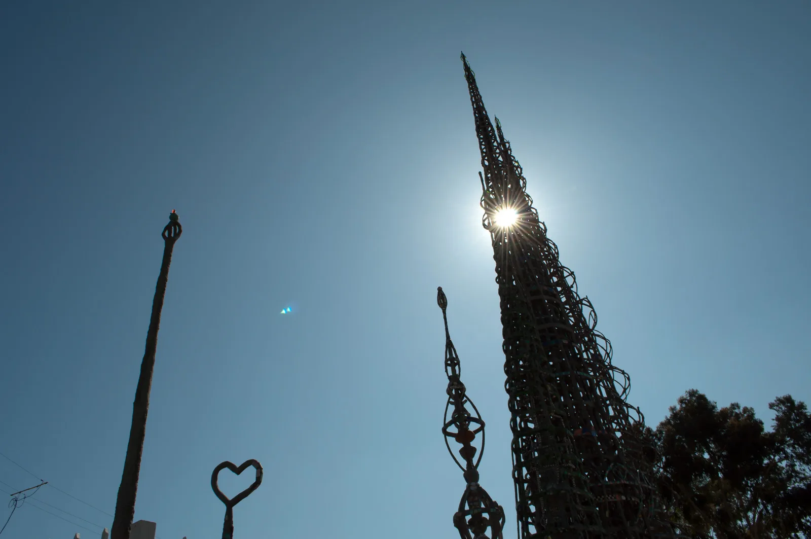 Spired tower silhouetted by the sun with a heart-shaped ornament