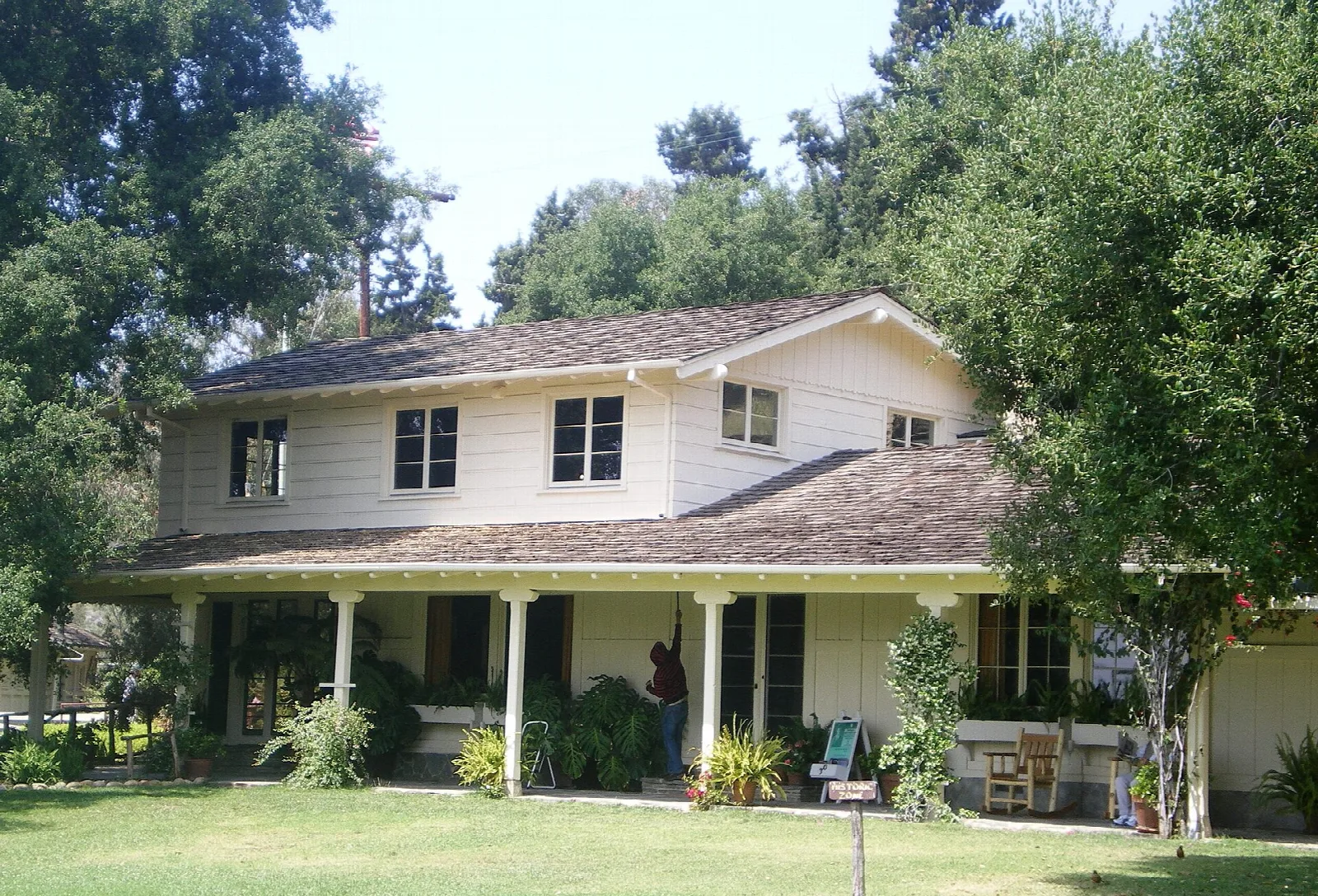 Two-story ranch house with a covered porch and lawn