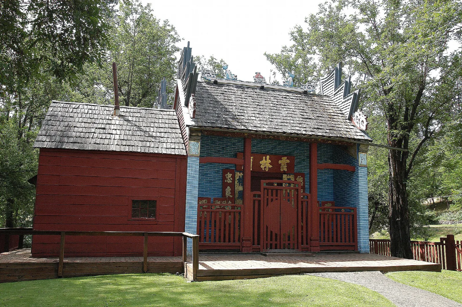 Red wooden temple with blue brick front and a stepped roofline