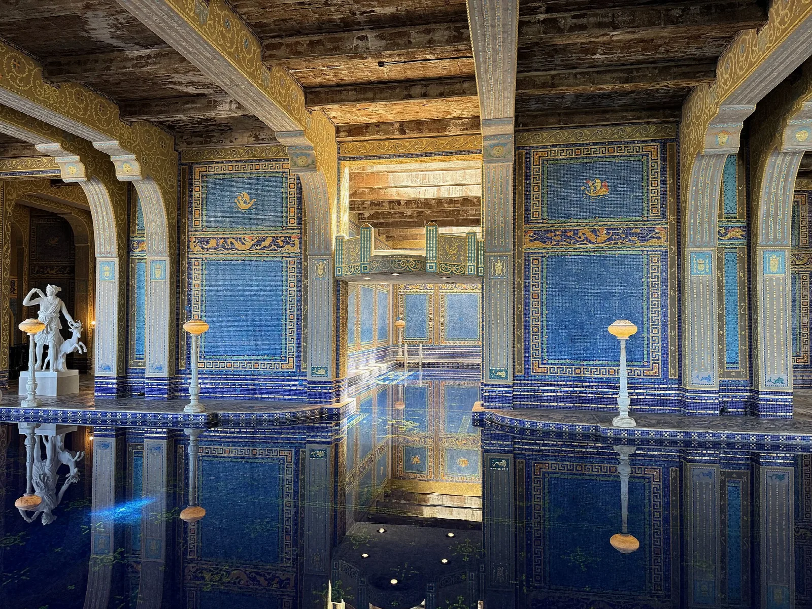 Indoor pool with blue and gold tile and statues