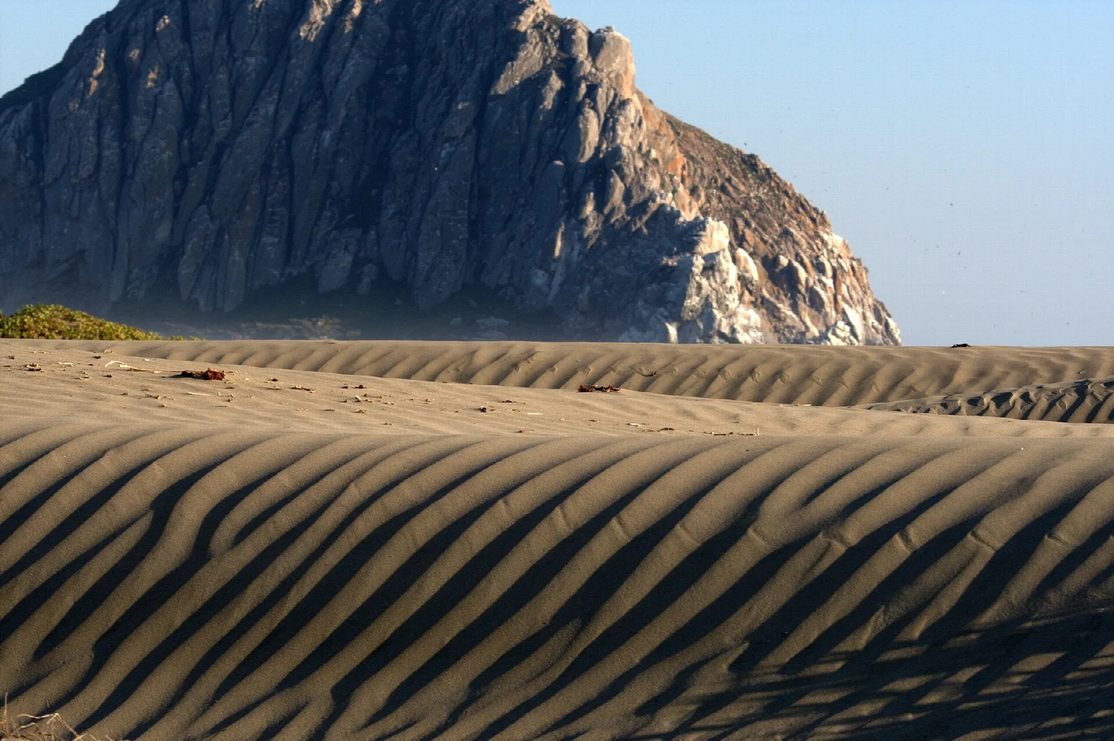 Rippled sand dunes with Morro Rock rising behind