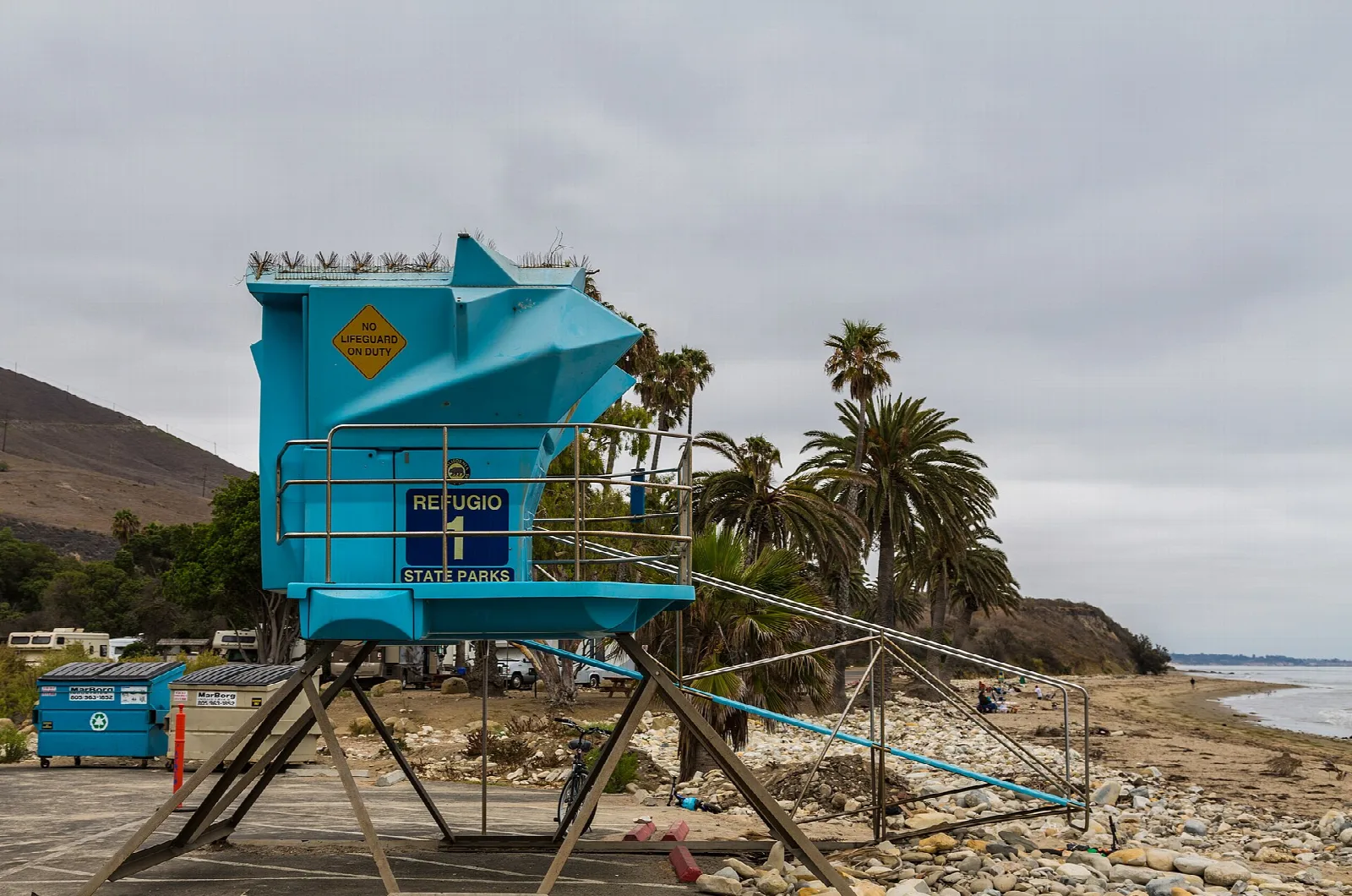 Blue lifeguard tower among palm trees on the beach