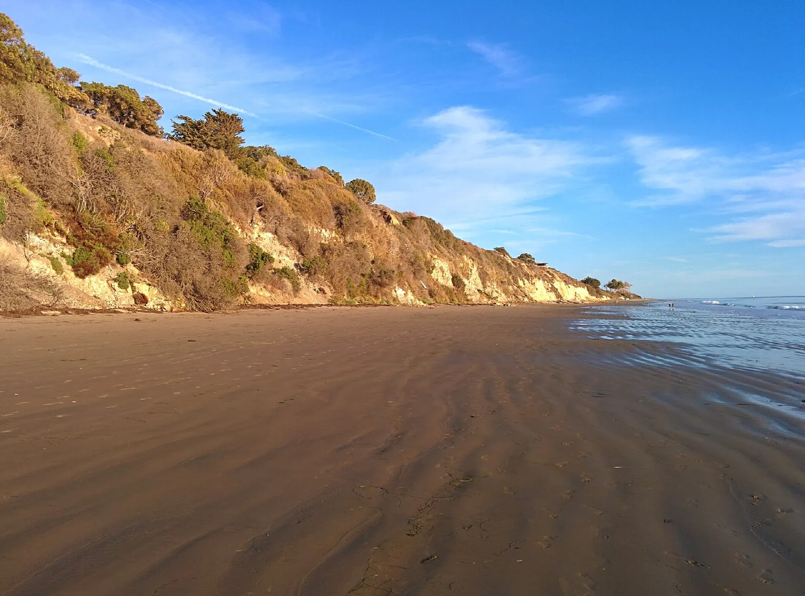 Sandy beach below golden bluffs with ocean to the right