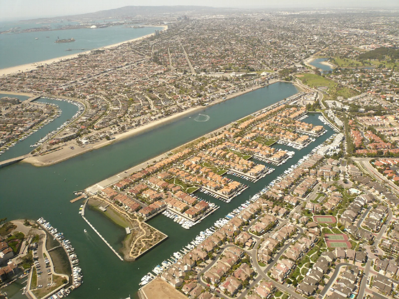Aerial view of a long straight water course with homes and docks on both sides