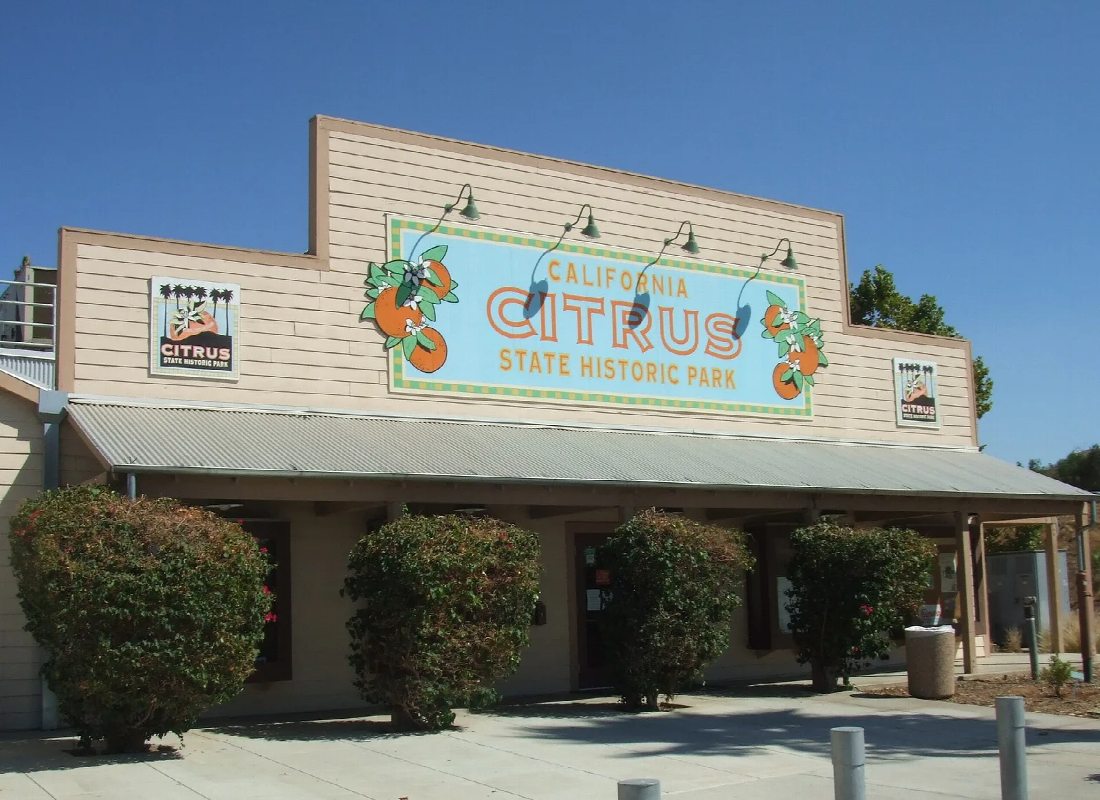 Wood building with a Citrus State Historic Park sign and shrubs