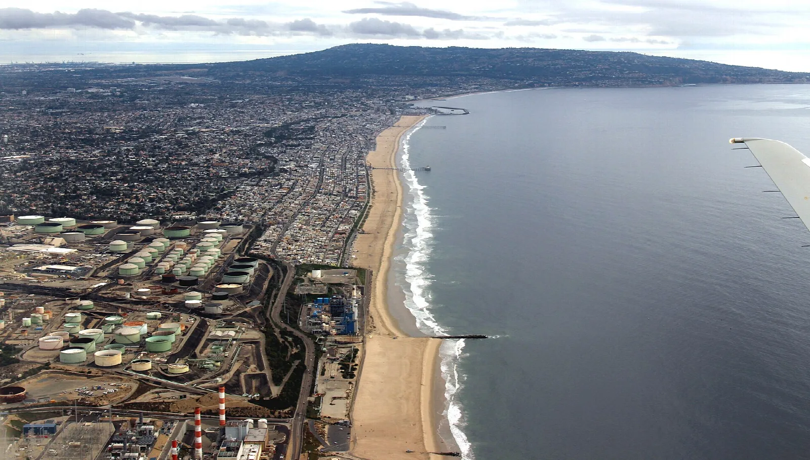 Aerial view of a long sand beach and ocean beside the city