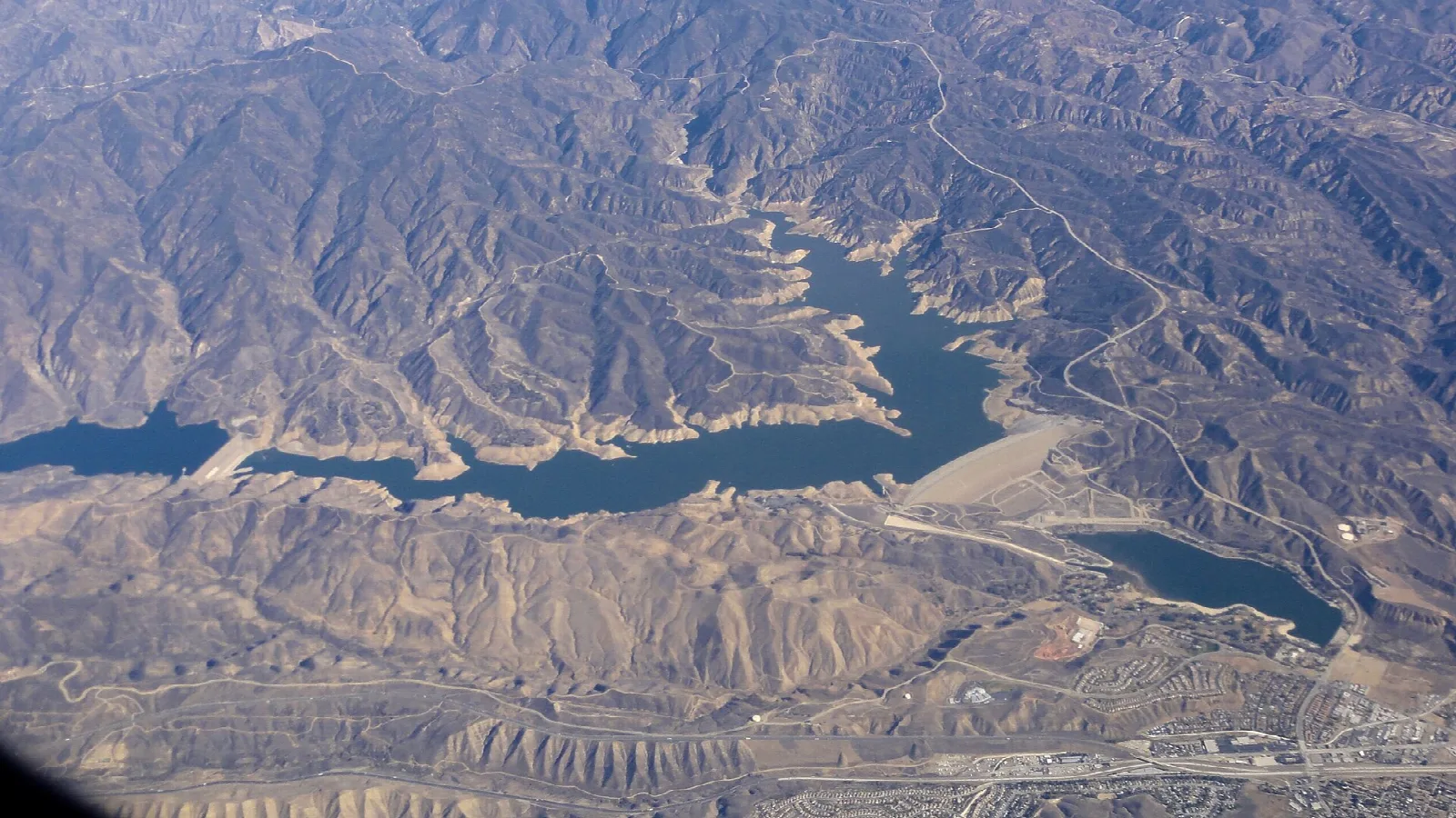 Aerial view of a narrow reservoir among dry mountains