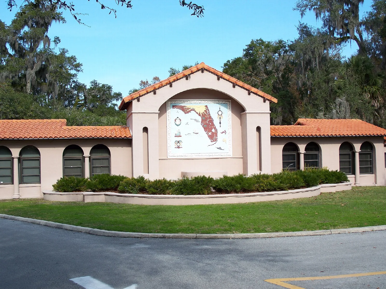 Park entrance sign building with tiled roof and green lawn