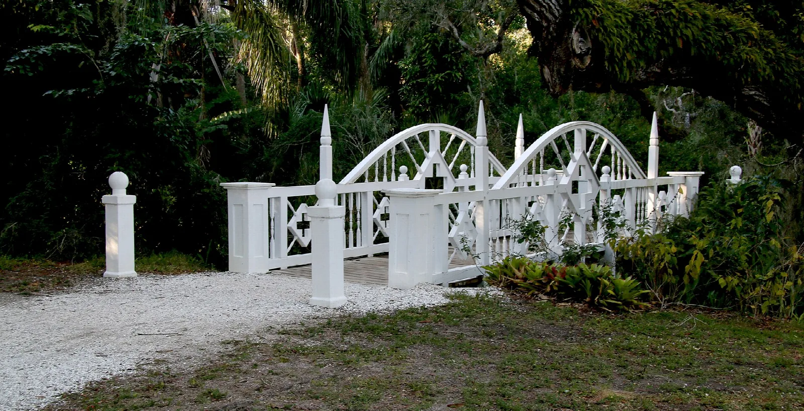 White ornamental wooden footbridge in a garden
