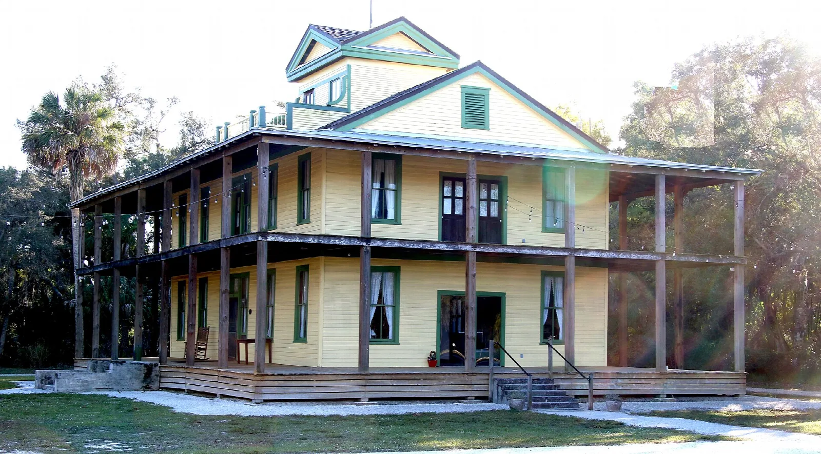 Large yellow wooden house with upper and lower porches