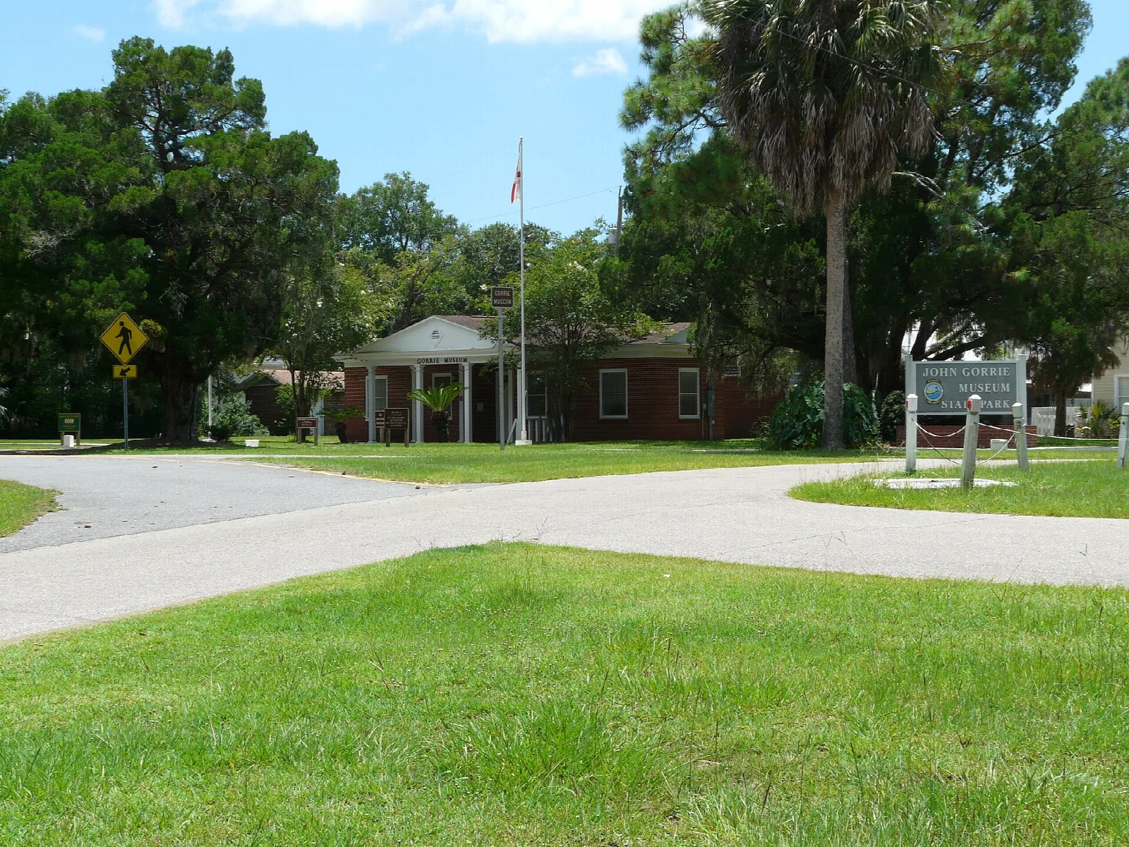 Museum grounds with a lawn, a flagpole and a low brick building