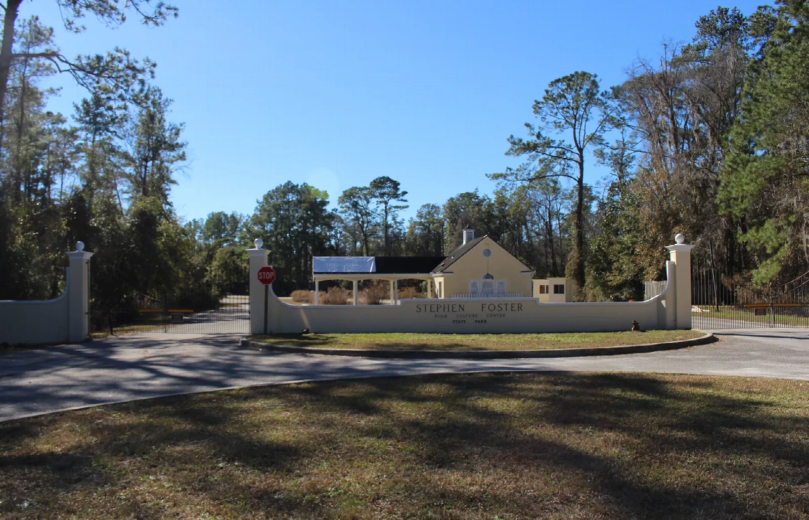 Park entrance gate and drive lined with pines
