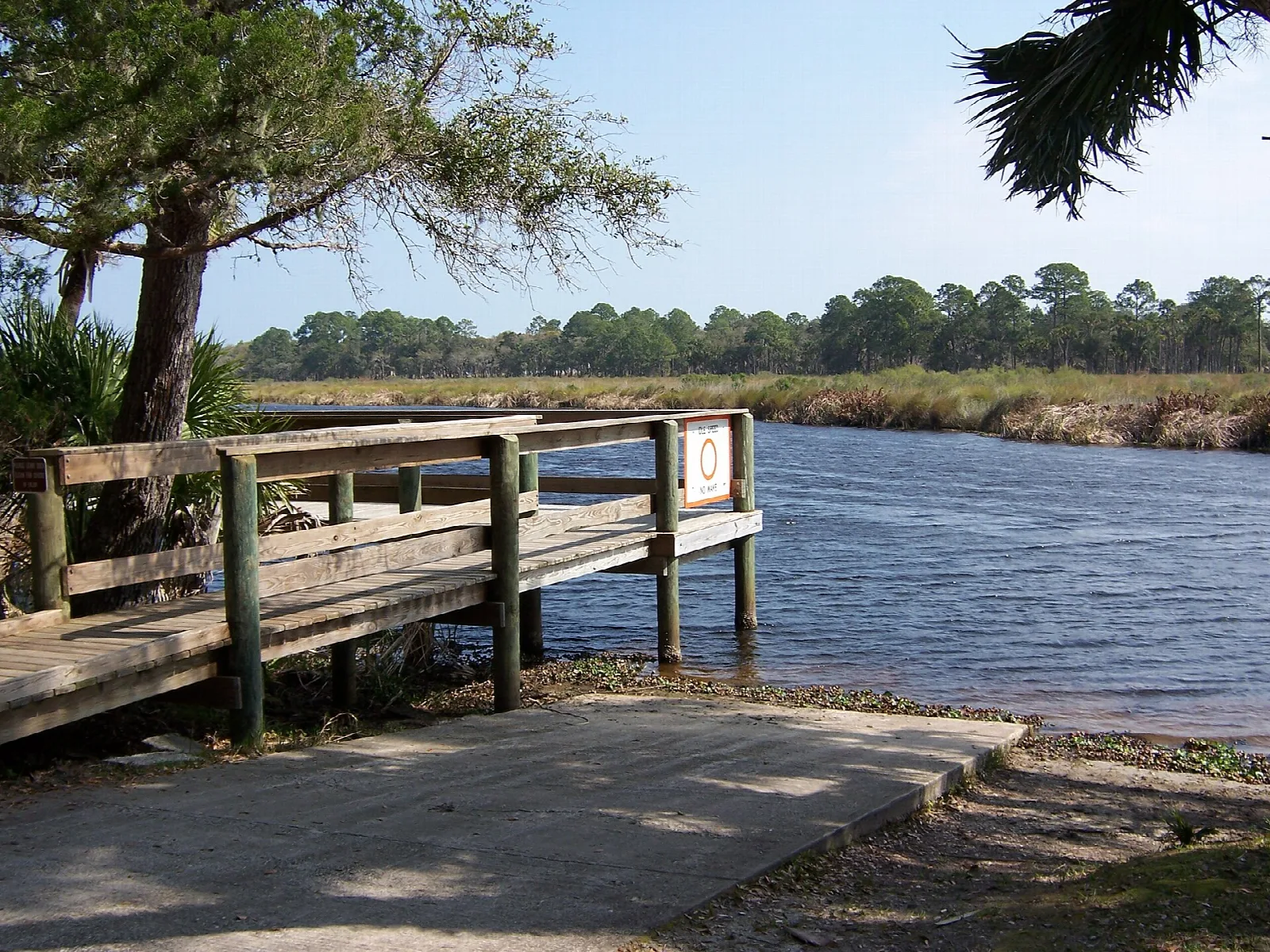 Wooden dock and boat ramp beside a creek