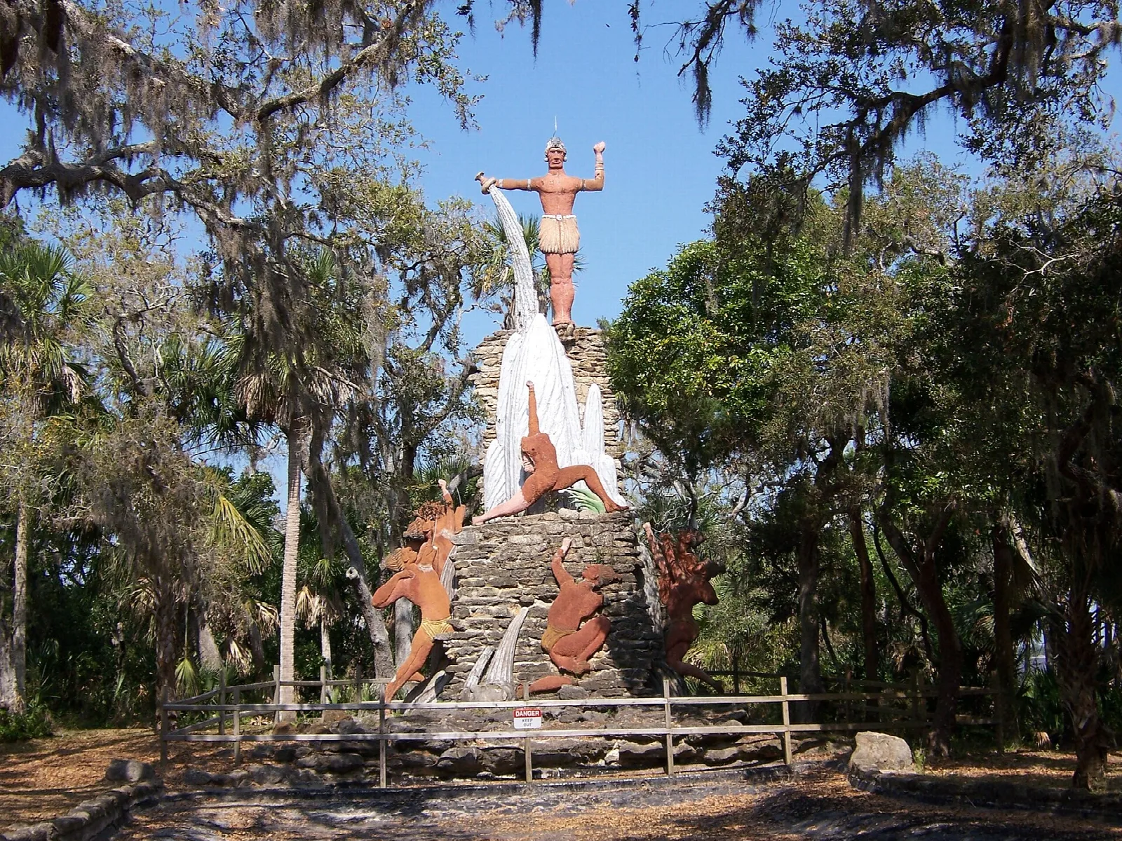 Statue on a rock base among oaks hung with Spanish moss