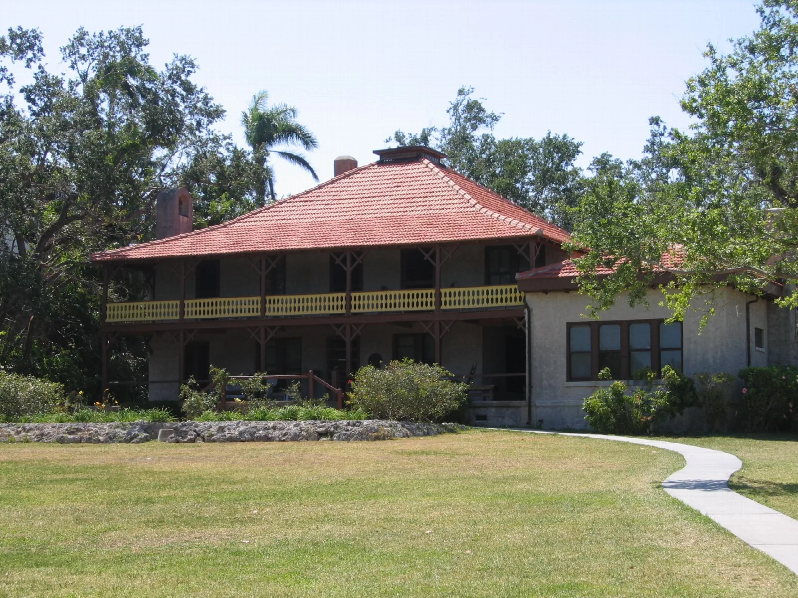 Two-story house with a red roof and a long second-floor porch