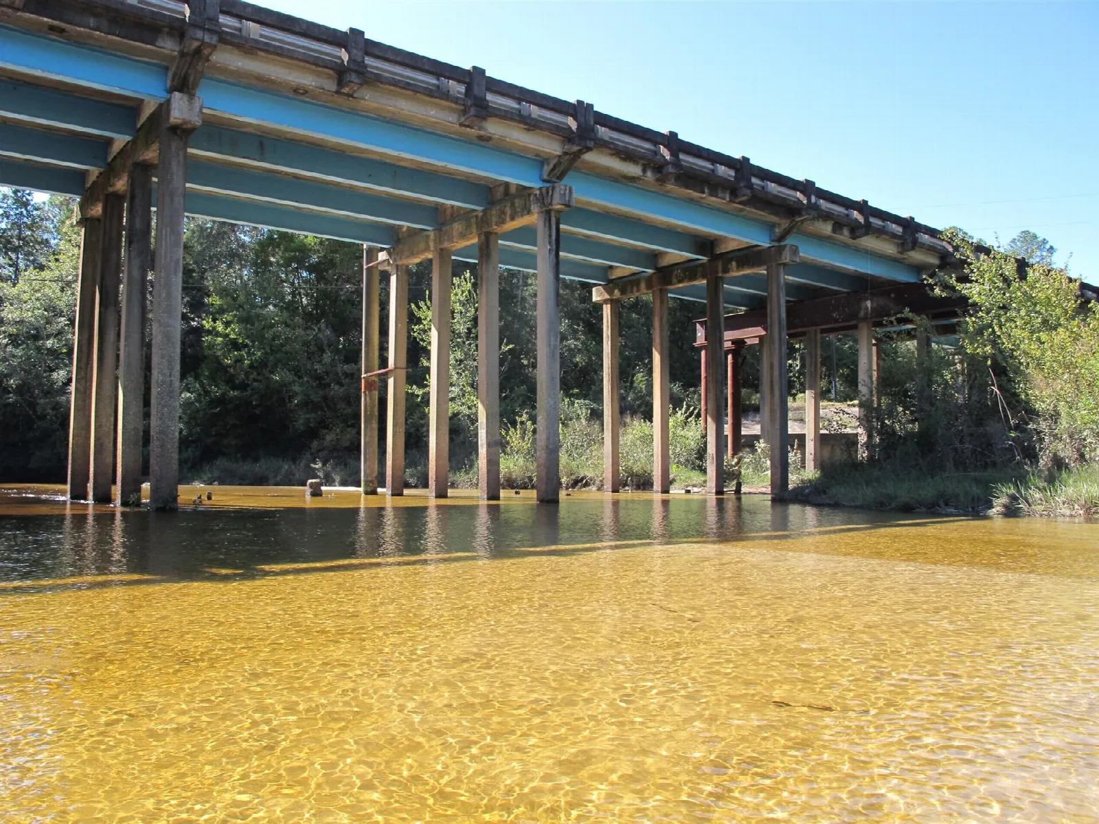 Wooden bridge crossing a river over amber water