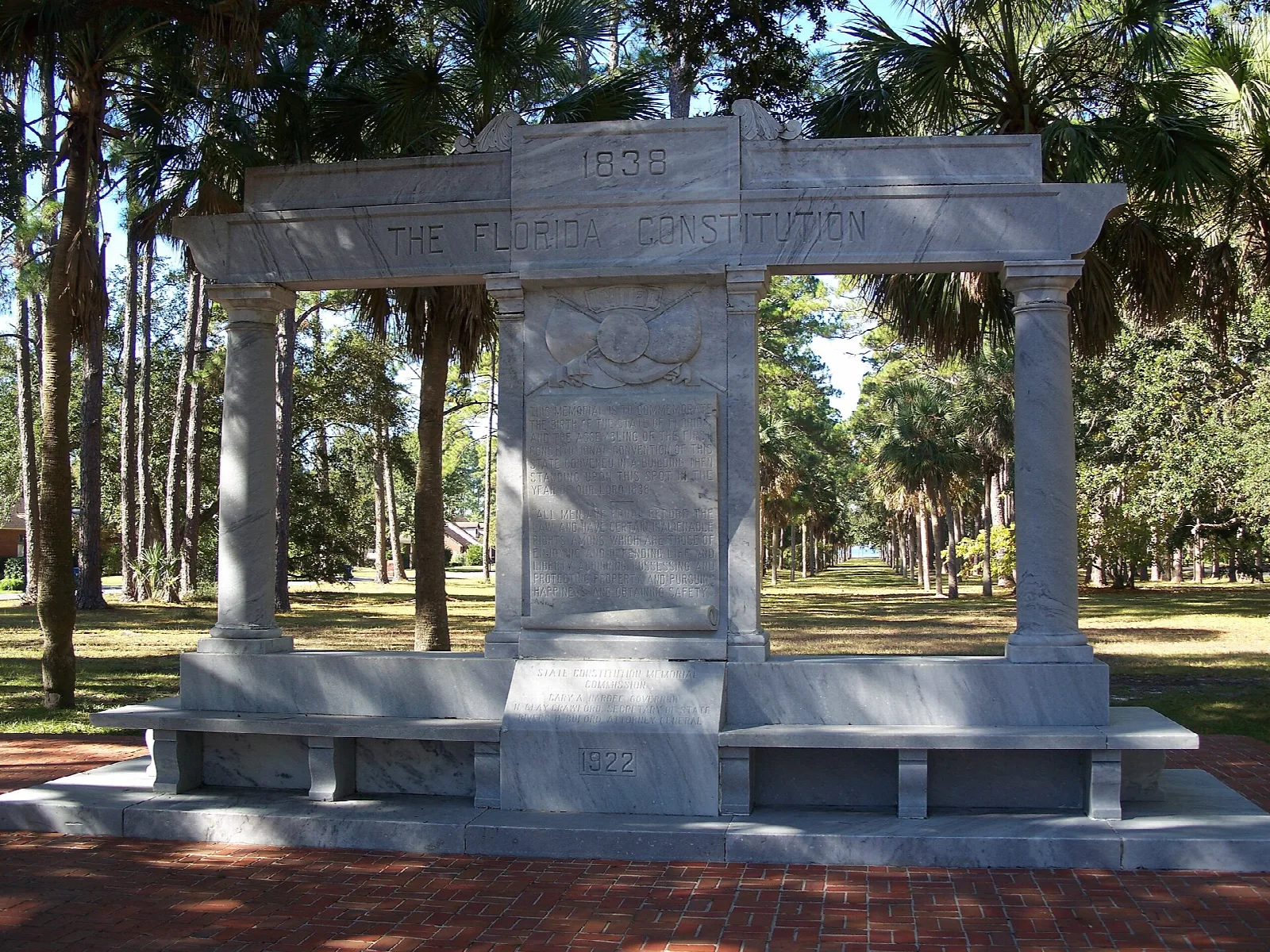 Large stone monument with benches among pines and palms