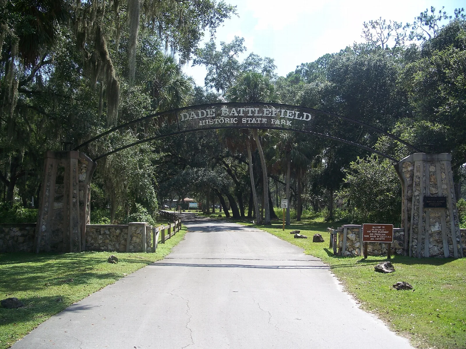 Gate arch with stone pillars over a paved park road