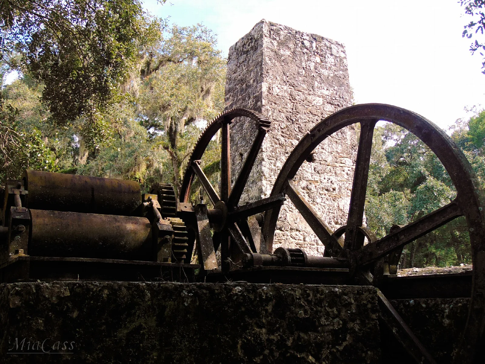 Iron wheels and rollers with the stone chimney behind