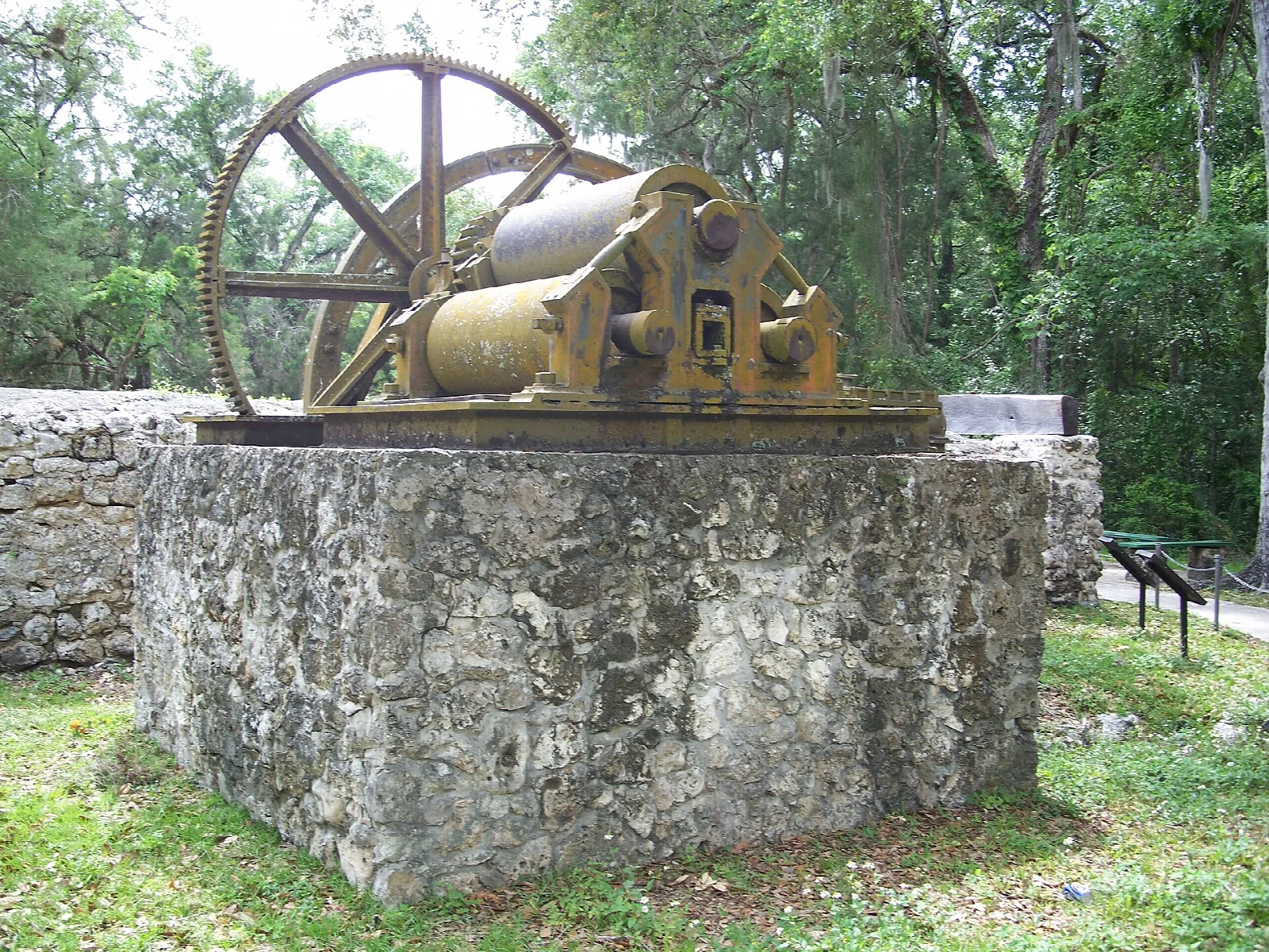 Old iron mill machinery on a stone base