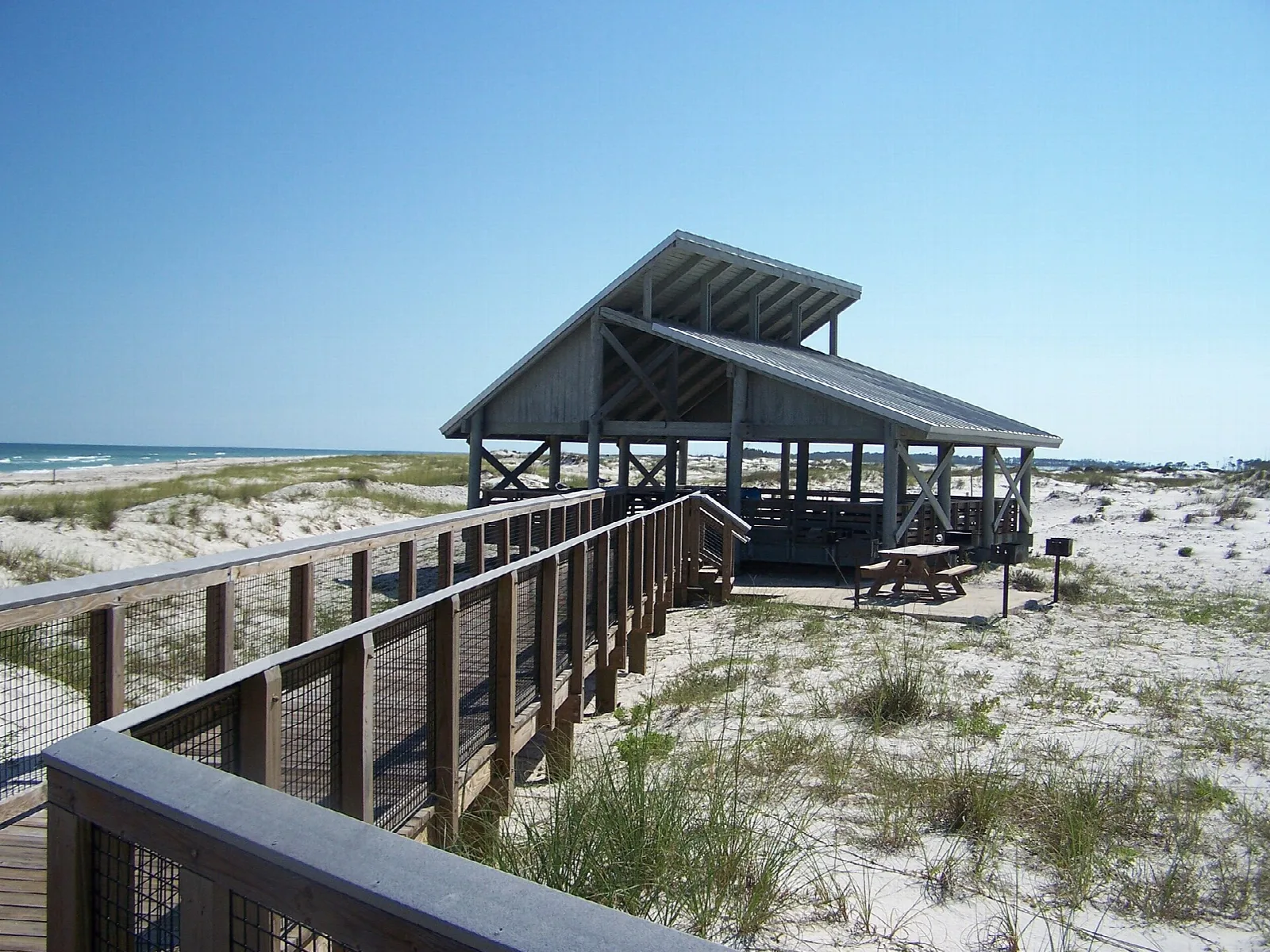Open wooden pavilion on a dune beside a boardwalk