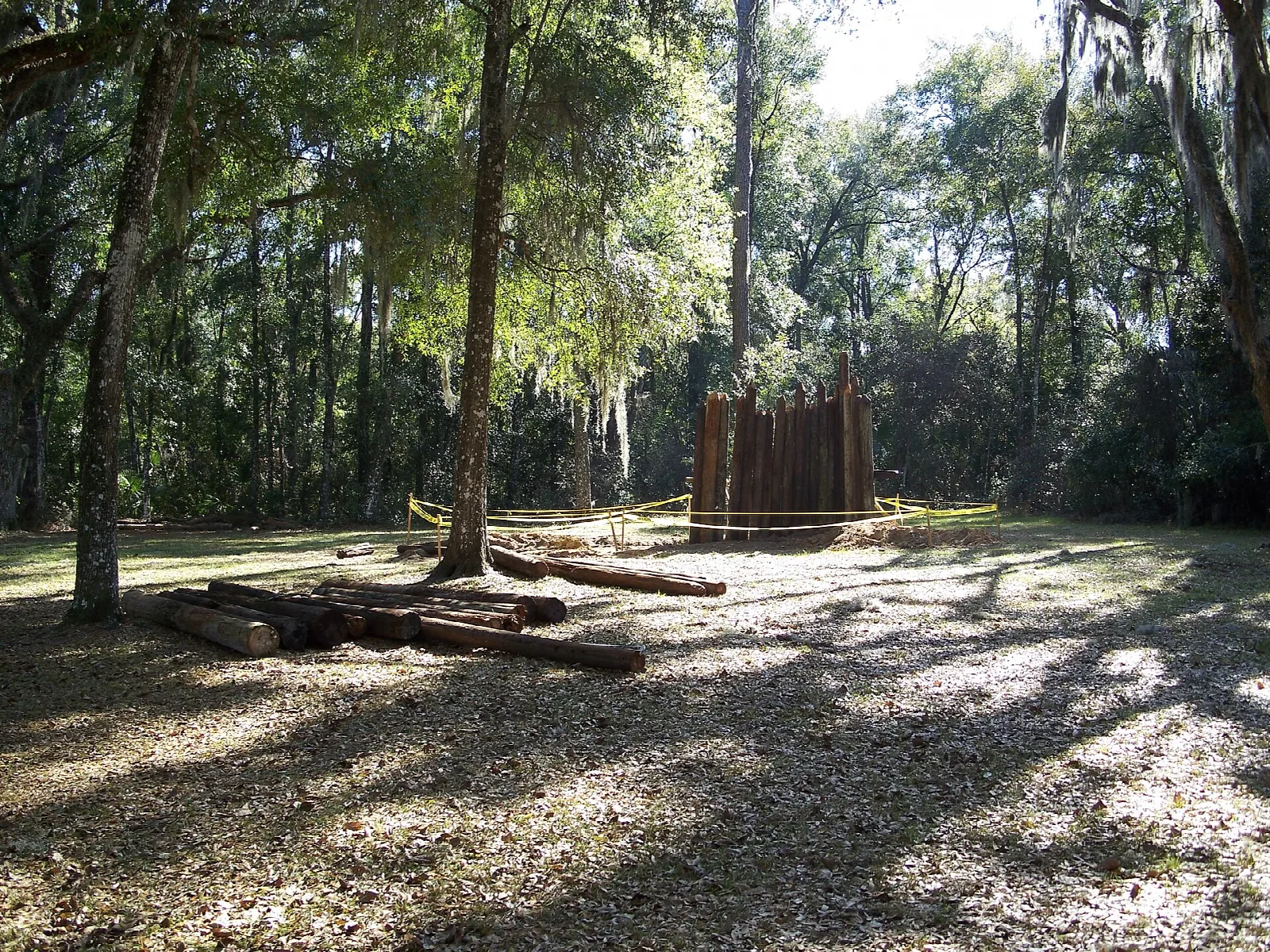 Log stockade among oaks with logs on the ground
