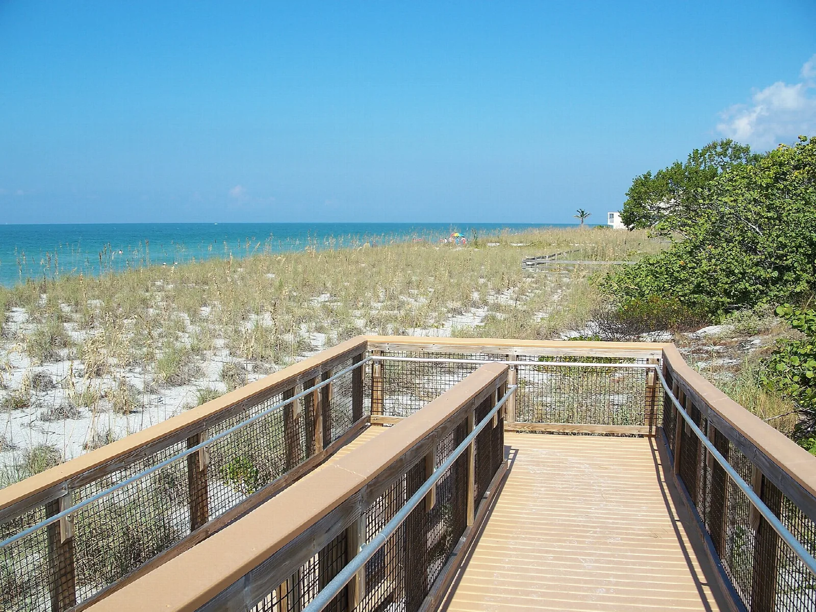 Wooden boardwalk crossing dunes toward the Gulf