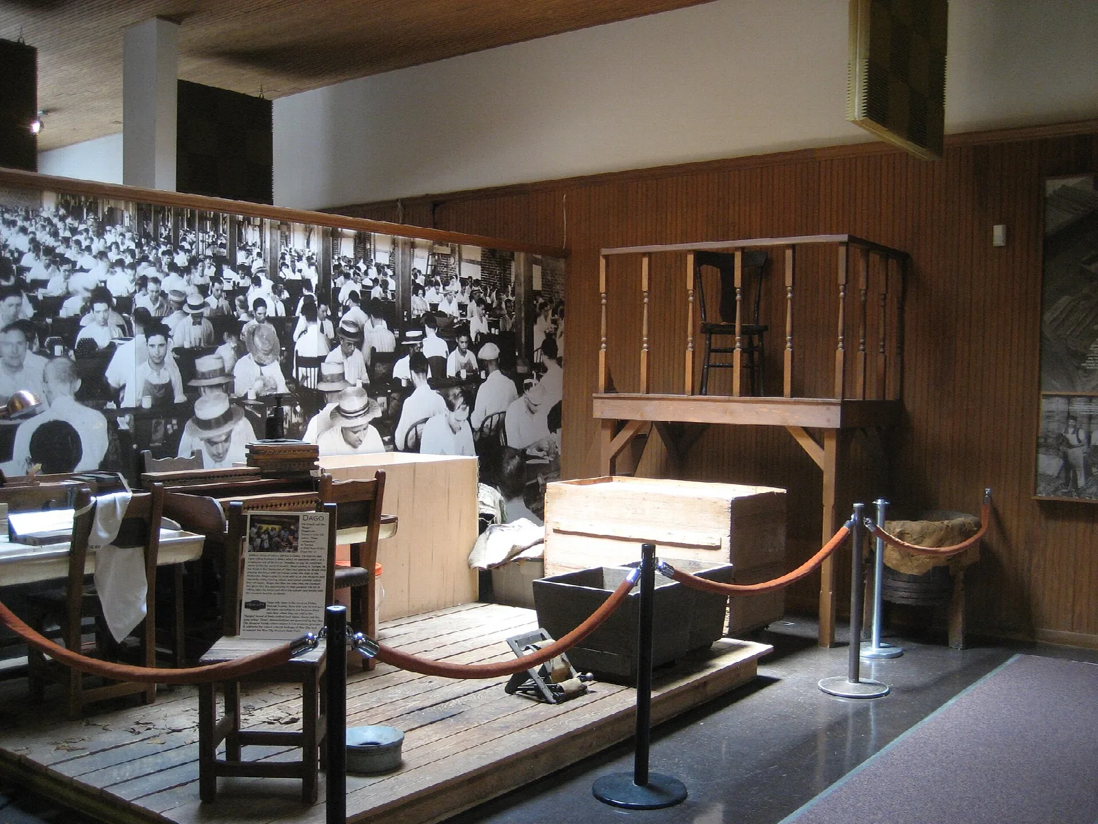 Cigar-rolling display with a large historic photo behind desks